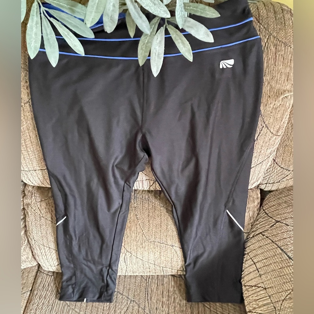 Marika Tech large size capri length black leggings with a blue piping at center.